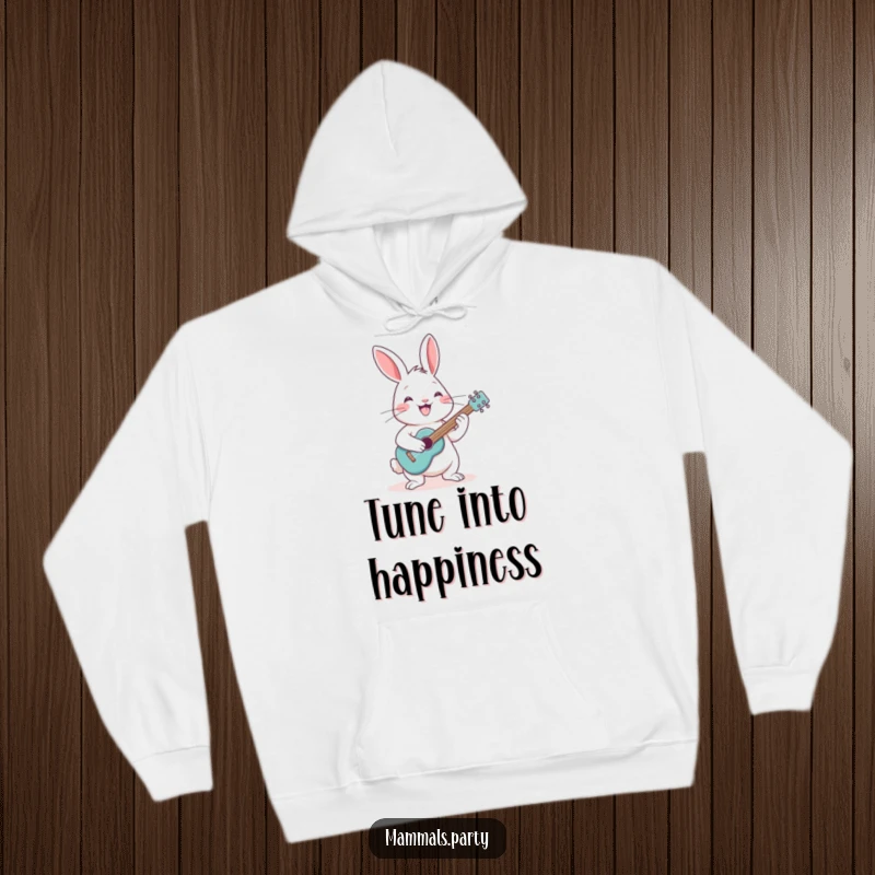 Funny cheerful rabbit with a grin, playing a tiny guitar, featured on a cozy hoodie for musical comfort.