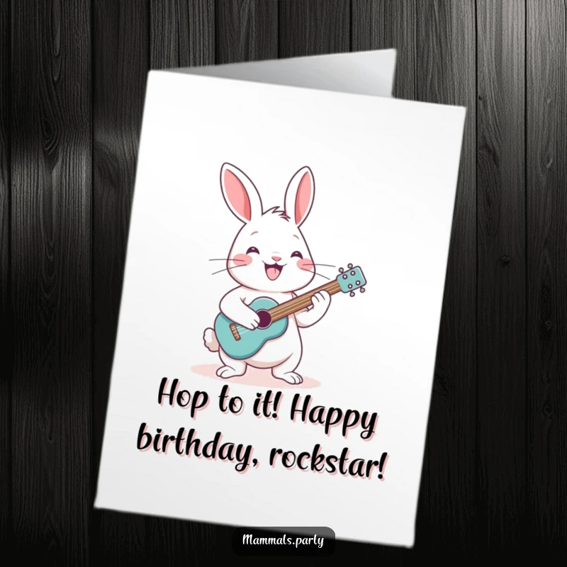 Funny Free Printable Birthday Card depicting a cheerful rabbit strumming a tiny guitar with a huge grin, ready to perform.